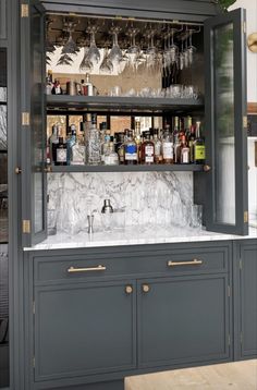 a bar with wine glasses and liquor bottles on the top shelf in front of it