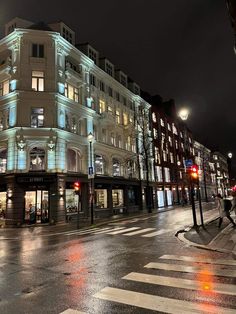 a city street at night with buildings lit up