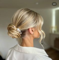 a woman with blonde hair in a low bun and pearled clip on her head