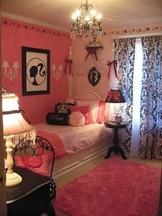 a bedroom decorated in pink, black and white with chandelier hanging from the ceiling