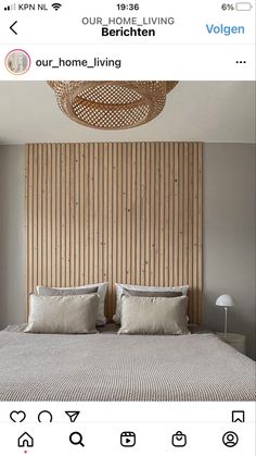 a bed with two pillows on top of it in front of a wooden headboard