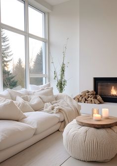 a living room filled with furniture and a fire place next to a large window on top of a wooden floor