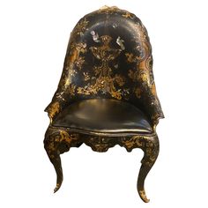 an antique chair with gold and black designs on it's back end, against a white background