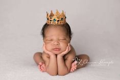 a newborn baby wearing a gold crown