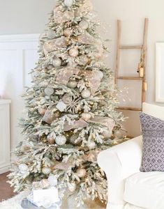 a white christmas tree with pink and silver ornaments