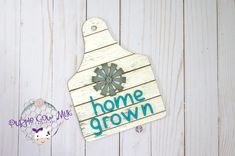 a wooden sign that says home grown with a flower on it next to a cow