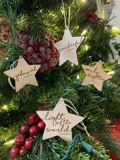 christmas ornaments hanging from the top of a tree with pine cones and berries on it