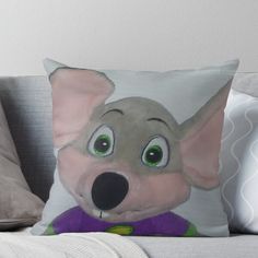 a pillow with an image of a cartoon mouse on it's face and green eyes