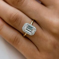 a woman's hand with an engagement ring on it and a diamond in the middle