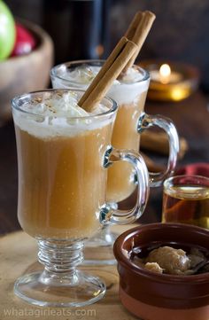 two mugs filled with drinks sitting on top of a table