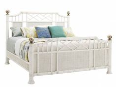 a white bed with wicker headboard and foot board is shown against a white background