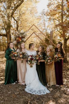 a group of women standing next to each other in front of trees