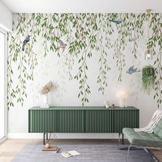 a living room with green furniture and wallpaper on the walls that has birds flying over it