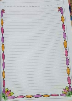 an open notebook with lined paper and colored pencils on the desk next to it