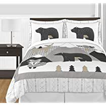 a bed with two bears and pine trees on the comforter, next to a night stand