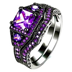 a ring with purple stones and black filigrees on the sides, set against a white background