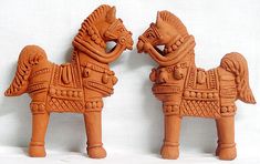 two clay horses are standing next to each other