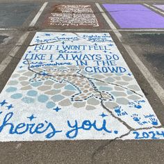 there's you written on the sidewalk with blue and white paint in front of it