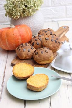 some muffins are on a plate next to pumpkins