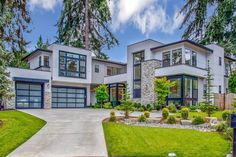 a large house with lots of windows in the front yard and landscaping on the side