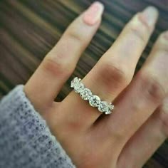 a woman's hand with a diamond ring on top of her finger and two diamonds in the middle