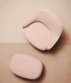 two pink chairs sitting next to each other on top of a carpeted floor in front of a beige wall