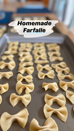 homemade farfalle pasta on a baking sheet with the words homemade farfalle above it