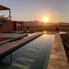 the sun is setting over an outdoor swimming pool