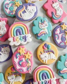 decorated cookies with unicorns, cats, and rainbows on top of a table