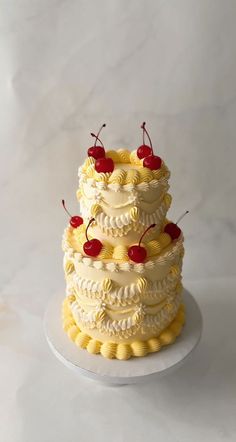 a three tiered cake with cherries on top