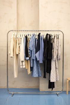 a rack with clothes hanging on hangers in a room