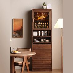 a dining room with a table and chairs next to a book shelf filled with bottles