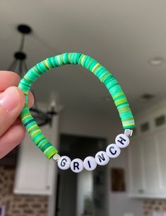 a person holding a green and white beaded bracelet with the word branch on it