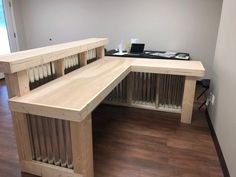 a wooden bench sitting next to a window on top of a hard wood floored floor