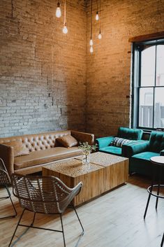 a living room filled with furniture next to a brick wall covered in light bulb lights