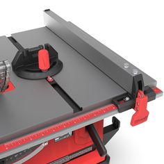 a red and black table sawing on top of a piece of metal with a measuring tape