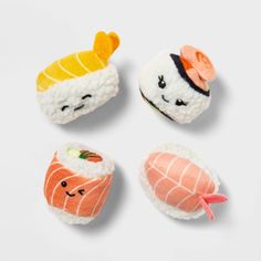 four sushi magnets are shown on a white surface, each with different types of sushi