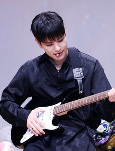 a young man is playing an electric guitar