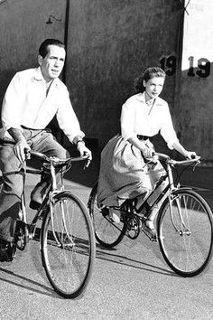 an old photo of two people riding bicycles