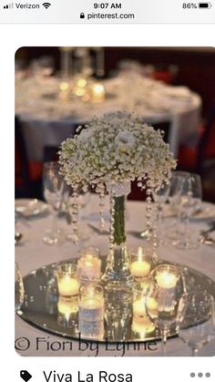 a centerpiece with flowers and candles on a table