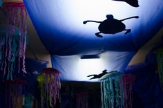 the silhouettes of two people are projected on an inflatable tent with tassels hanging from it