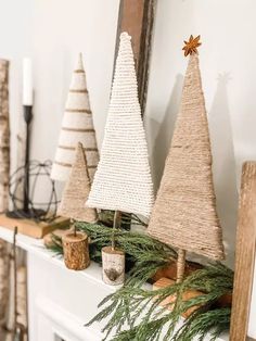 three small christmas trees on top of a mantle