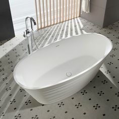 a white bath tub sitting on top of a tiled floor