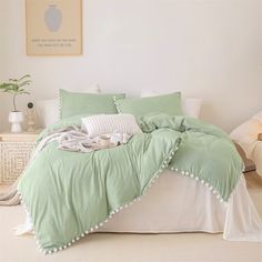 a bed covered in green and white sheets