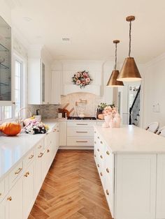 a kitchen filled with lots of white cabinets and counter tops covered in stars hanging from the ceiling