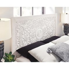 a white headboard with black and white pillows