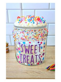 a jar filled with cake and sprinkles on top of a wooden table