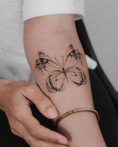 a woman's arm with a butterfly tattoo on it