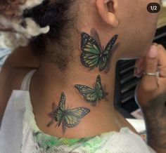 a woman with a tattoo on her neck has three butterflies