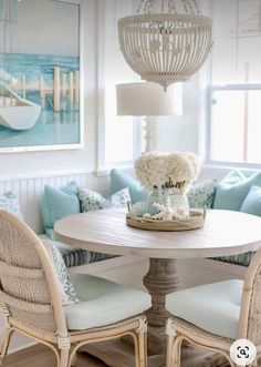 a dining room table with chairs and a chandelier hanging from it's ceiling